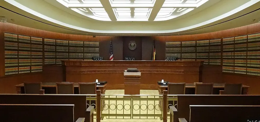 An empty United States courtroom, seen from the public gallery towards the bench.